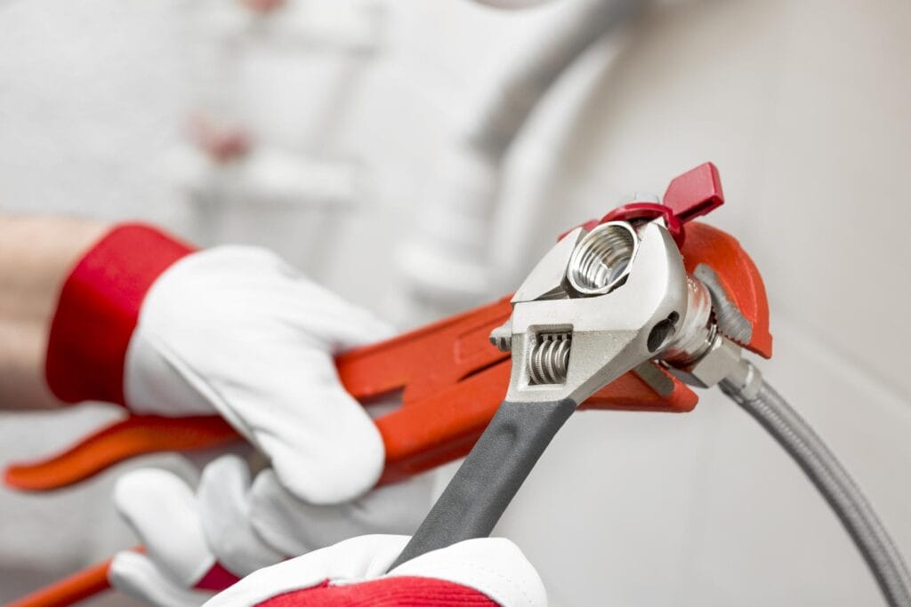 Plumber holding pipe wrenches for an emergency repair in Lancaster