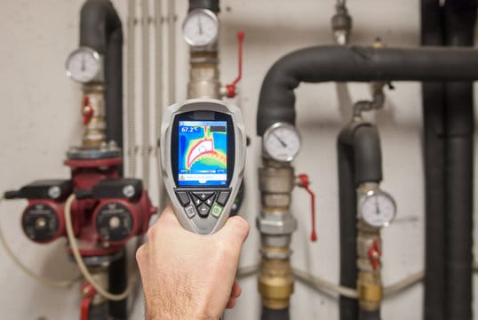 Plumber using a thermal imaging camera to inspect pipes in Lancaster