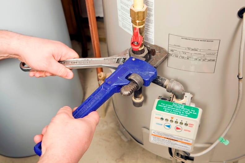 Plumber repairing a water heater valve in Lancaster